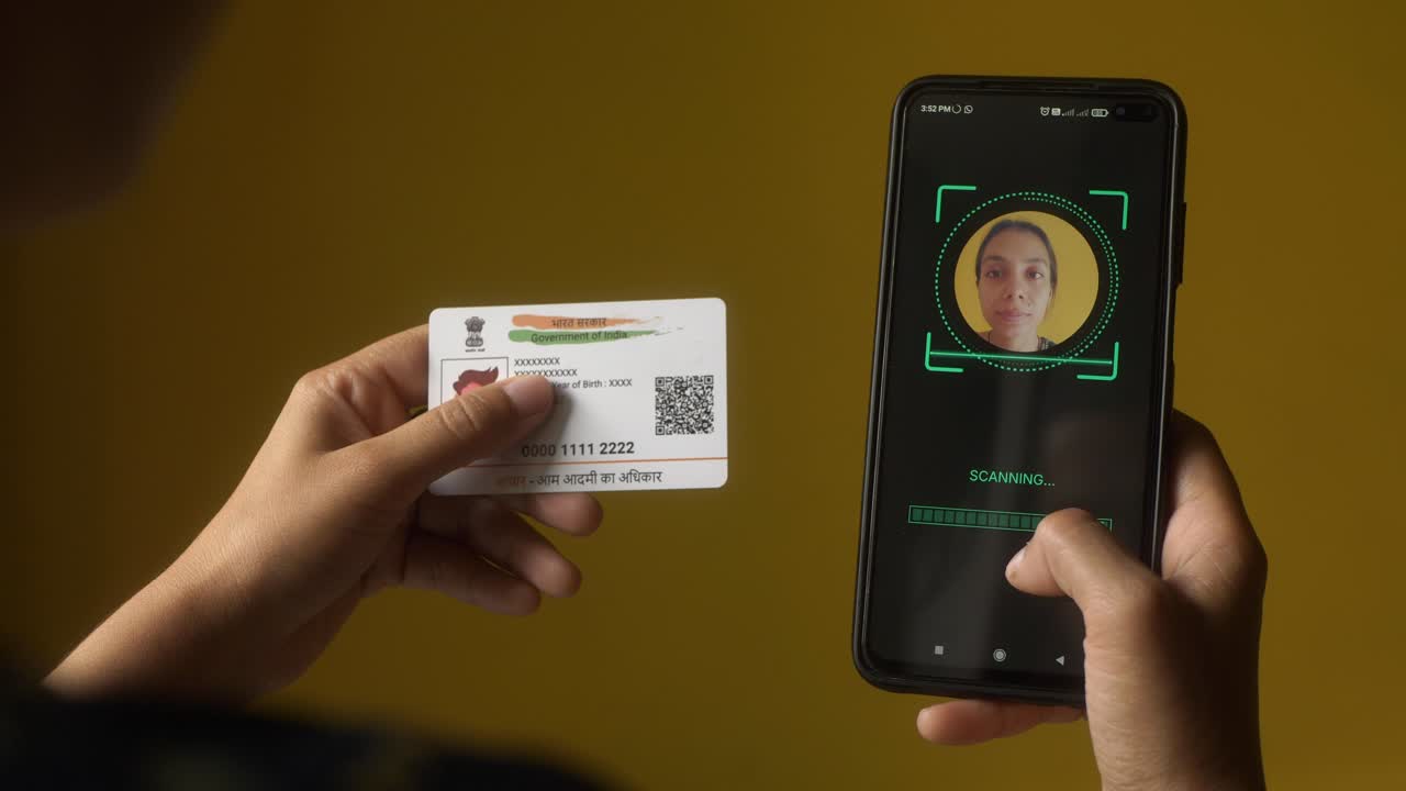 Indian nationality woman scanning her face on mobile phone for eKYC digital identity verification using Aadhaar card