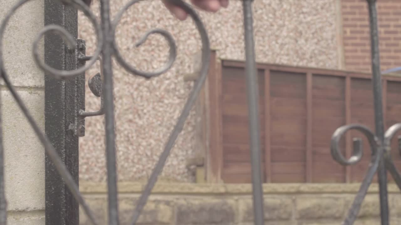 abriendo una puerta de hierro forjado