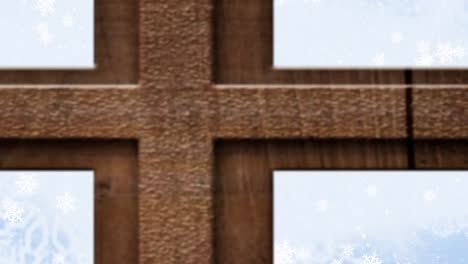 christmas tree and wooden window frame over snowflakes falling against blue background