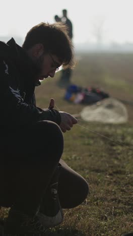 A man is squatting outdoors