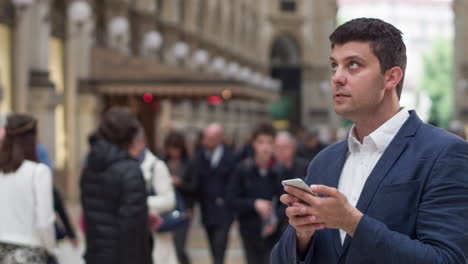 man using phone in a city street