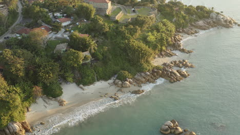 Sunset-drone-aerial-view-of-sea-waves-and-ocean-brazilian-rocky-coast,-Jurere-Internacional,-Florianopolis,-Santa-Catarina,-Brazil