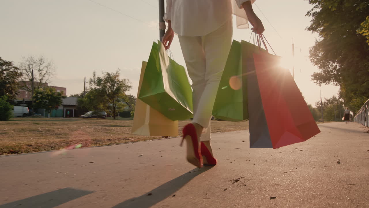 쇼핑 패키지로 만족한 쇼핑객이 골목을 걸어갑니다.