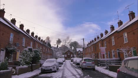 quaint slow motion shot of a village street with terrace cottages during the snow