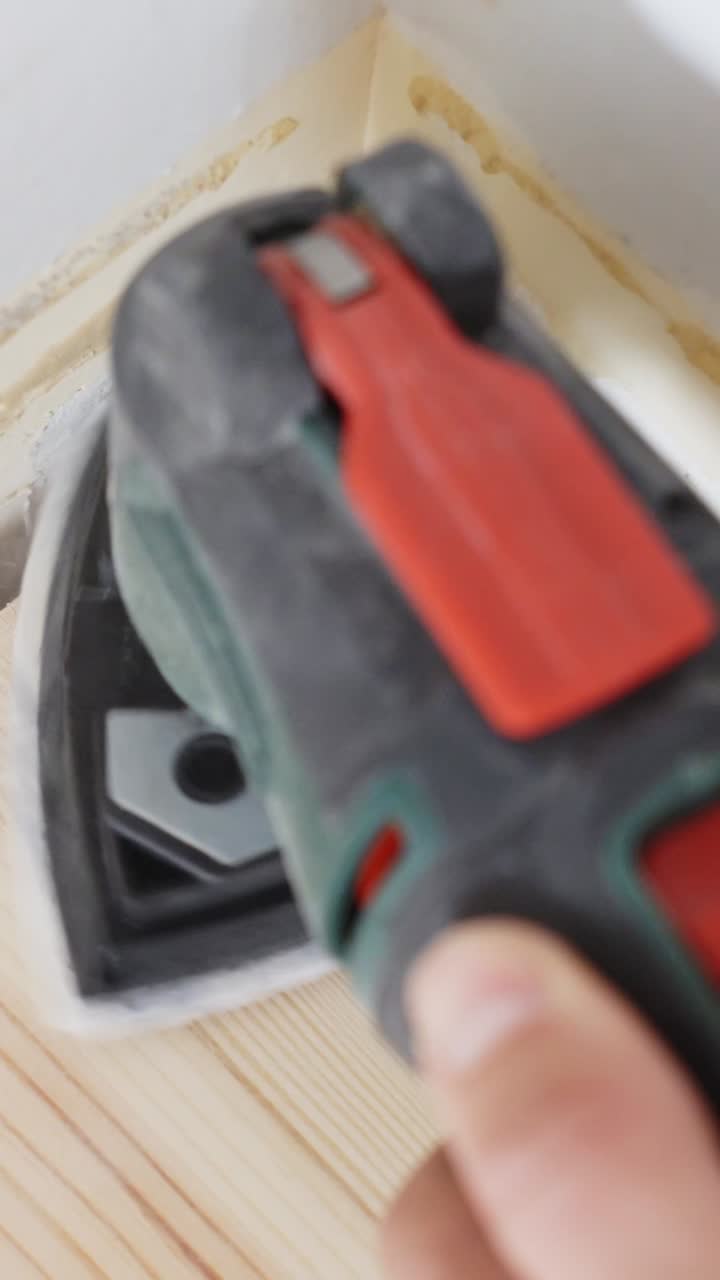 Close-up of an electric sander polishing a wooden surface during a DIY renovation