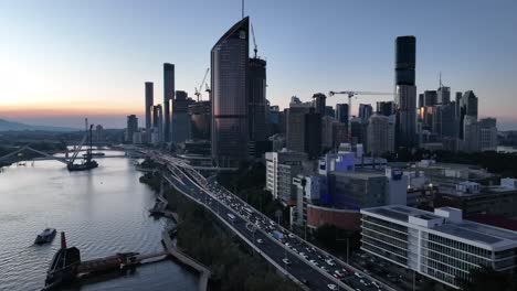 Tracking-aerial-shot-off-Brisbane-City,-flying-over-Brisbane-River,-Captain-Cook-Riverside-Expressway-Bridge