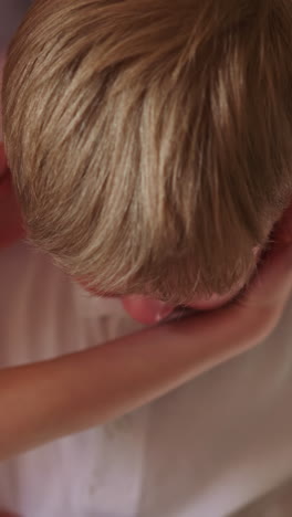 little boy wipes tears with t-shirt and schoolgirl comforts kid in bedroom closeup. sad child deals with traumatic experience with sister support