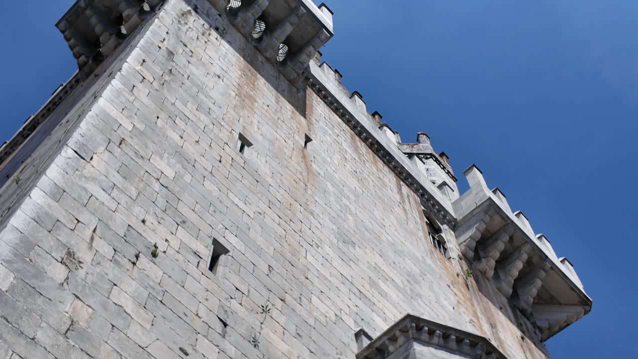 Majestic medieval Castle of Beja in Alentejo, Portugal, showcasing its impressive stone walls and battlements under a vibrant blue sky