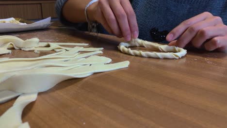 close up of hands while preparing fresh homemade italian pasta