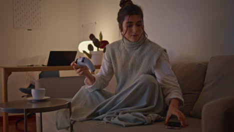 biting lips lady playing computer game in late living room. girl checking phone