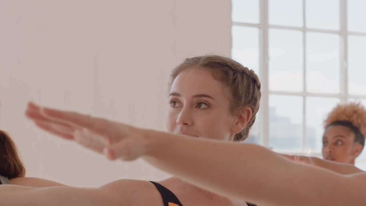 clase de yoga mujer caucásica saludable practicando pose guerrera disfrutando de un estilo de vida físico haciendo ejercicio con personas multiétnicas en un estudio de entrenamiento