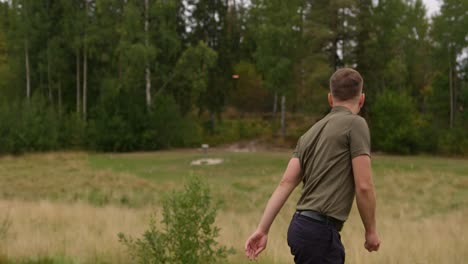 Disc-Golfer,-Der-Einen-Rückhandwurf-Macht,-Um-Sich-Dem-Korb-Zu-Nähern---Mittlerer-Schuss