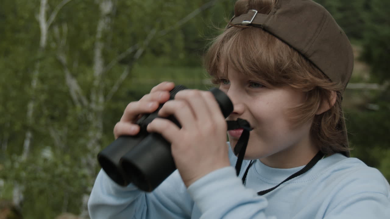 Boy with binoculars looking in nature