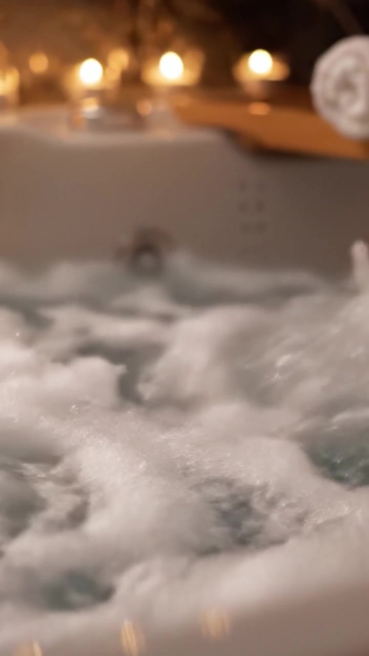 A Relaxing Bath Experience: Embrace Tranquility with Bubbling Water and Ambient Lighting in a Cozy Spa Setting