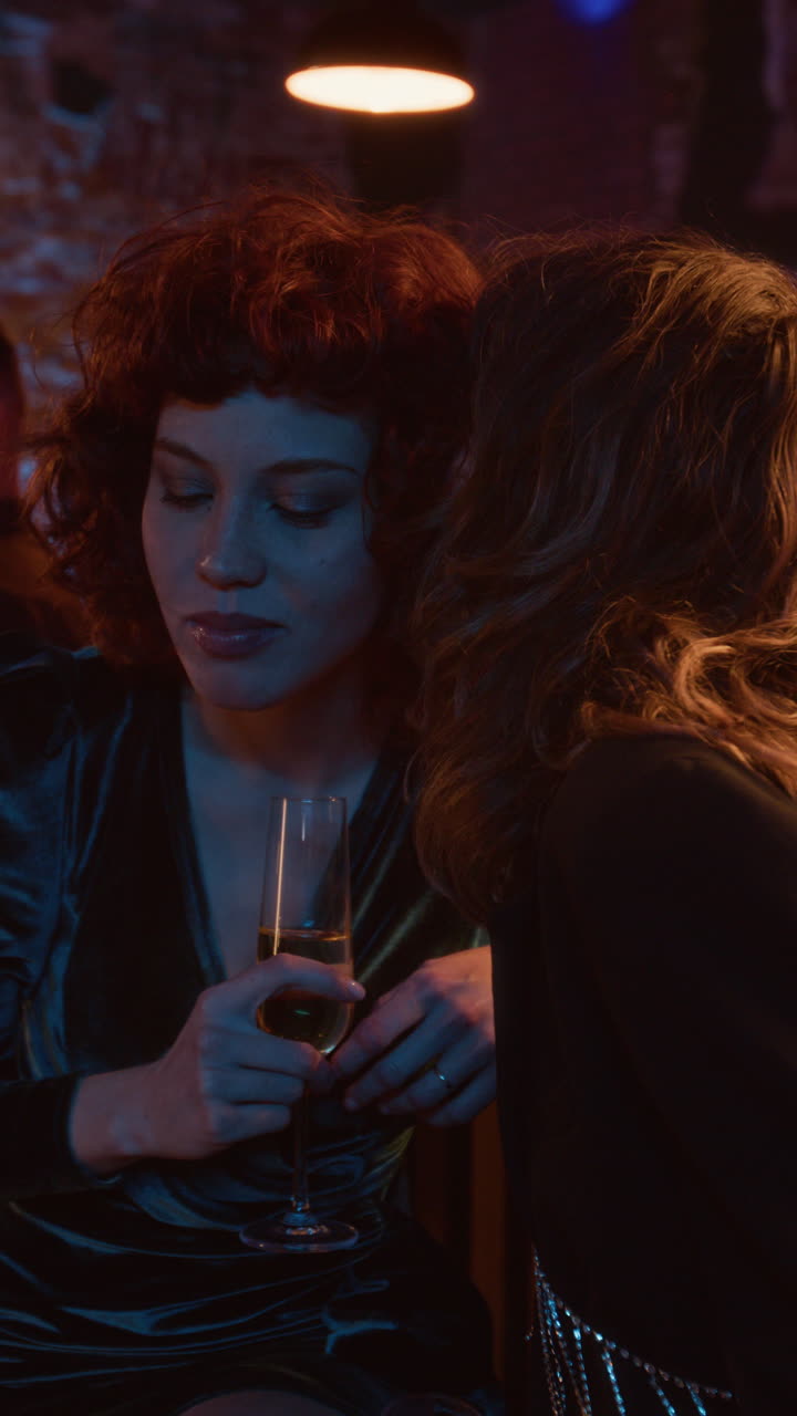 Two women drinking champagne at a party