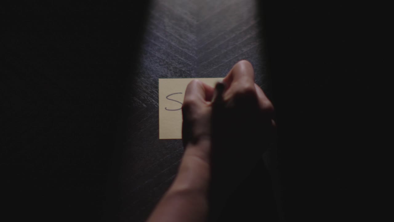 "Shit" written on a Sticky Note with a sharpie and placed on a table under dramatic lighting