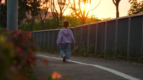 Sad-Little-Girl-Walking-Alone-at-Sunset-in-Slow-Motion-with-Sun-Setting-Behind-Mount