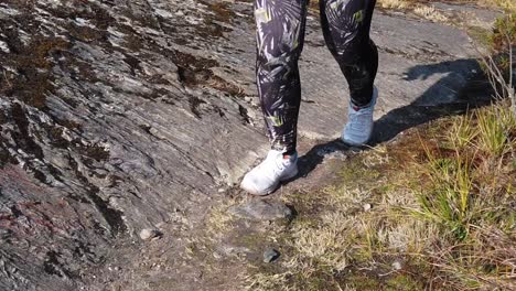 Slow-motion-pan-from-right-to-left-with-a-girl's-feet-trekking-the-famous-route-known-as-5-Lakes-of-Pichgacocha-in-Ambo,-Huanuco,-Peru