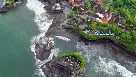 tanah lot temple and surrounding village buildings with tile rooftops in bali indonesia