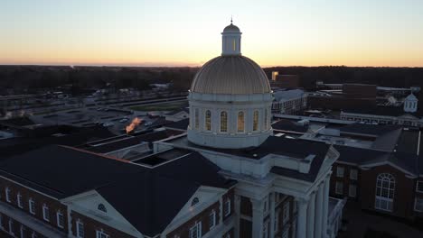 christopher newport hall with dome on university campus at sunset