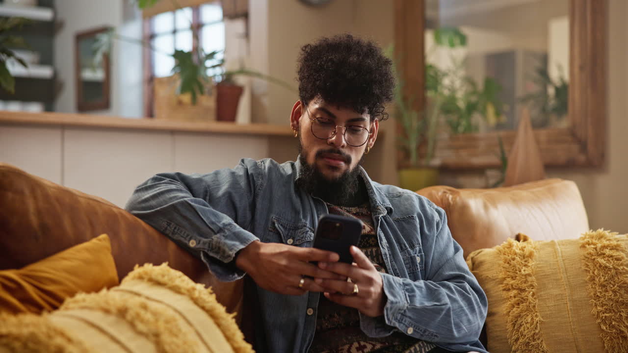 Man sitting on a couch using his phone