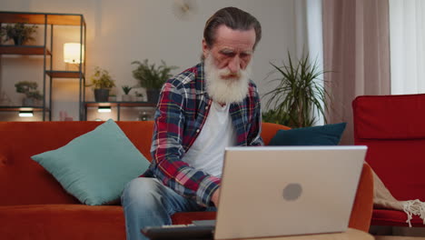 sad senior old grandfather man use laptop surprised by bad news, fortune loss, fail, lottery results