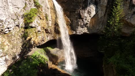 stunning berglistüber waterfall flowing from rocky cliffs into pool in glarus, switzerland, sunlight glows water and view