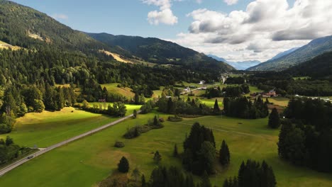 julian alps landscape with country road in sunny vibrant summer day, aerial view