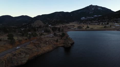 Cars-On-Mountain-Valley-Road-By-Lake-Aerial-Pan-Shot-4K