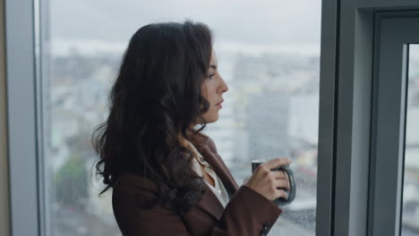 office manager drinking coffee standing at window close up. woman work break.