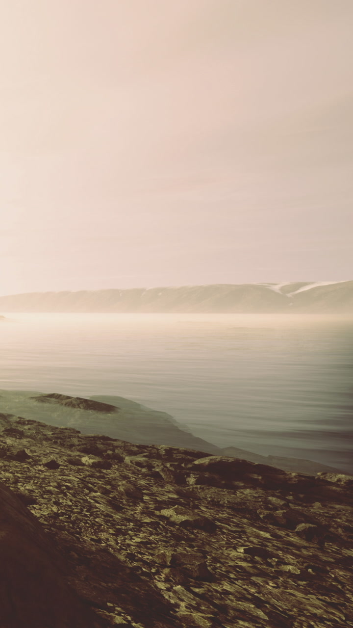 The scene shows smooth water with a slight ripple next to rocky shores