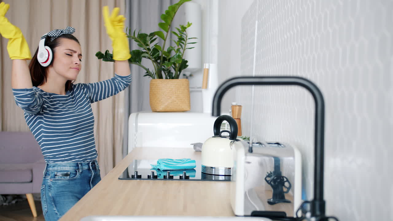 Woman Cleaning Kitchen While Dancing to Music