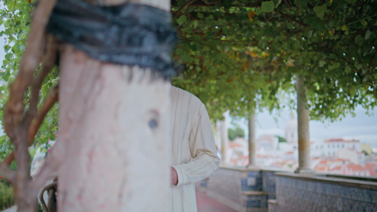 꽃을 들고 있는 섹시한 남자가 골목길에서 드폰을 이용해 문자를 읽고 있다.