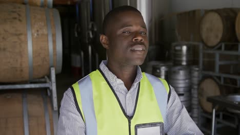 hombre afroamericano sonriendo a la cámara y usando chaleco de alta visibilidad