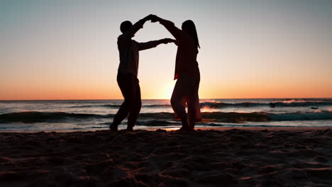 playa, baile al atardecer y silueta de la pareja
