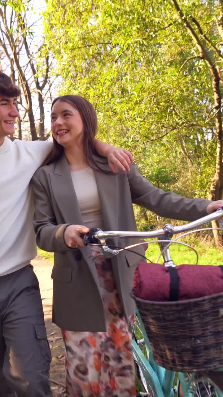 Couple walking with a bike in the park