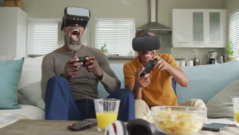 Video-Eines-Glücklichen-Afroamerikanischen-Vaters-Und-Sohnes,-Die-VR-Headsets-Tragen-Und-Videospiele-Spielen