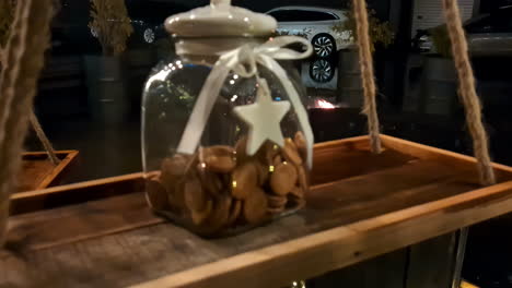 jar of miniature cookies on a rustic swing shelf hanging outdoor