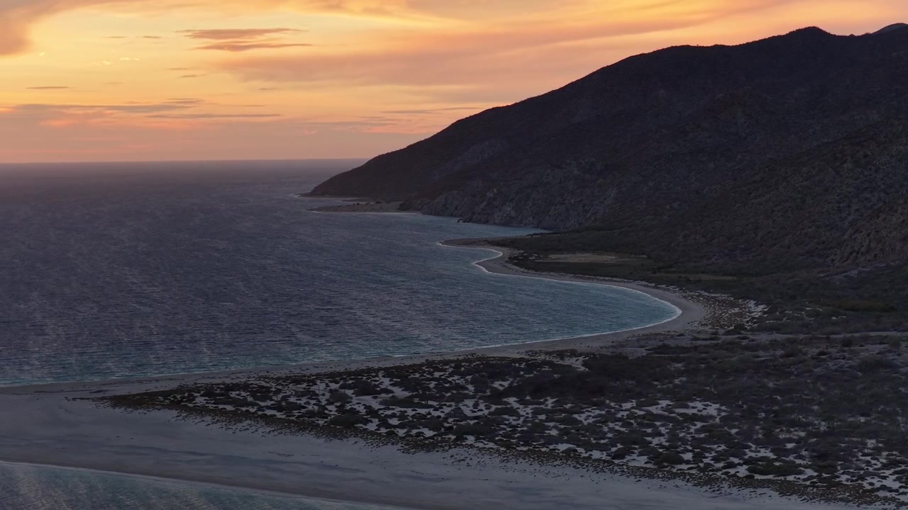 Luftfoto af kystlinjen ved Isla Cerralvo, Baja California Sur, under en smuk solnedgang.