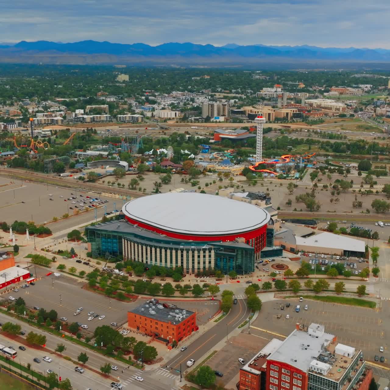Sight of Elitch Gardens amusement theme park in Denver, Colorado, USA. Green city view at backdrop of mountains. Aerial view