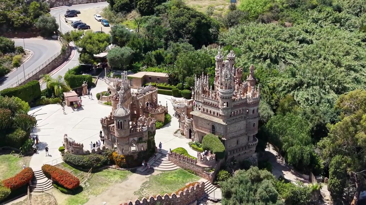 İspanya, Málaga, Benalmádena'daki Colomares Kalesi kompleksinin drone havadan genel görünümü; süslü kuleler, dekoratif mimari, avlular ve bahçeler içeriyor.