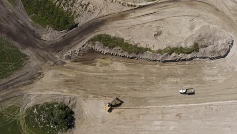 Toma-Aérea-De-Arriba-Hacia-Abajo-De-Equipo-Pesado-Trabajando-En-Un-Sitio-De-Construcción-Sucio