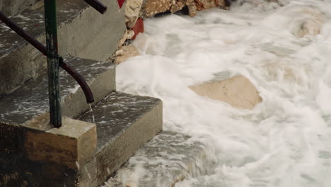 Ocean-waves-crash-on-exposed-concrete-slabs-eroded-away-from-water-exposure