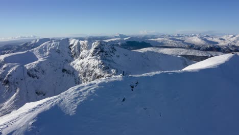 mountaineer man reaching the top of a snow-capped mountain