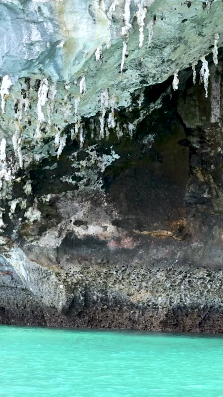 cueva con estalagmitas sobre aguas claras de color turquesa