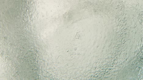 top view of underwater deep blue ocean during raining seeing ripple and wave water with bubble moving on surface with sunlight. it is beautiful pattern and texture for background.