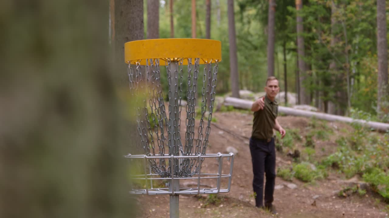 Disc golfer makes a perfect putt into the basket