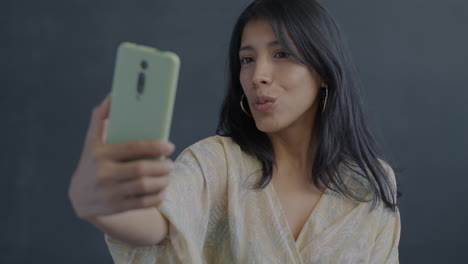 woman taking a selfie with a light green smartphone