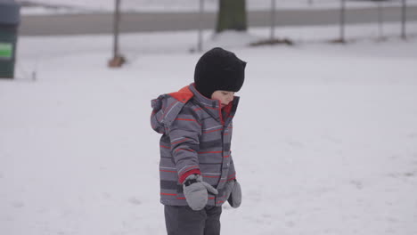 Der-Kleine-Junge-Blickt-Verwundert-Auf-Den-Frisch-Gefallenen-Schnee