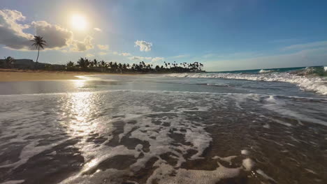 Puesta-De-Sol-En-La-Playa-De-Punta-Cana,-Isla-Dominicana-De-Hispaniola-Con-Palmeras-Al-Fondo-Y-Olas-En-Una-Playa-De-Arena